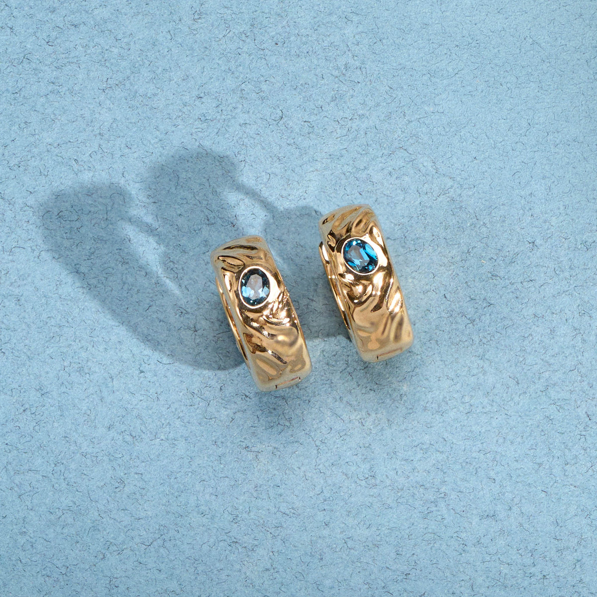 Créoles Sonia dorées texturées en plaqué or 18 carats ornées d’une topaze London Blue bleu profond
