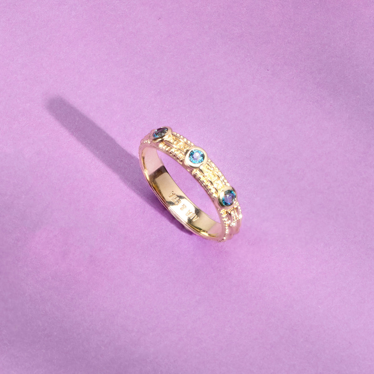 Bague Astra dorée en plaqué or 18 carats ornée de trois topazes London Blue bleu profond et d’un anneau fin texturé