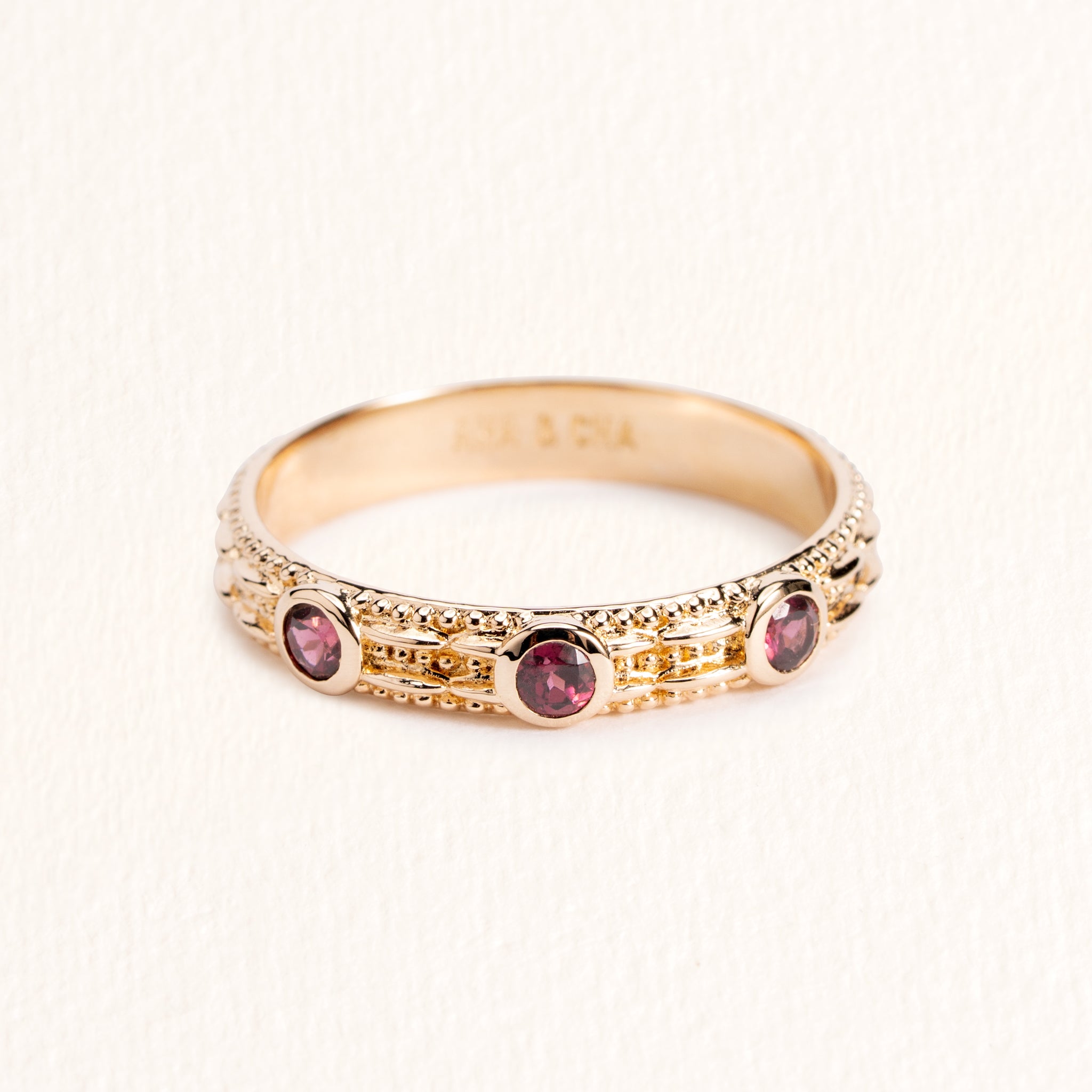 Bague Astra dorée en plaqué or 18 carats ornée de trois rhodolites framboise et d’un anneau fin texturé