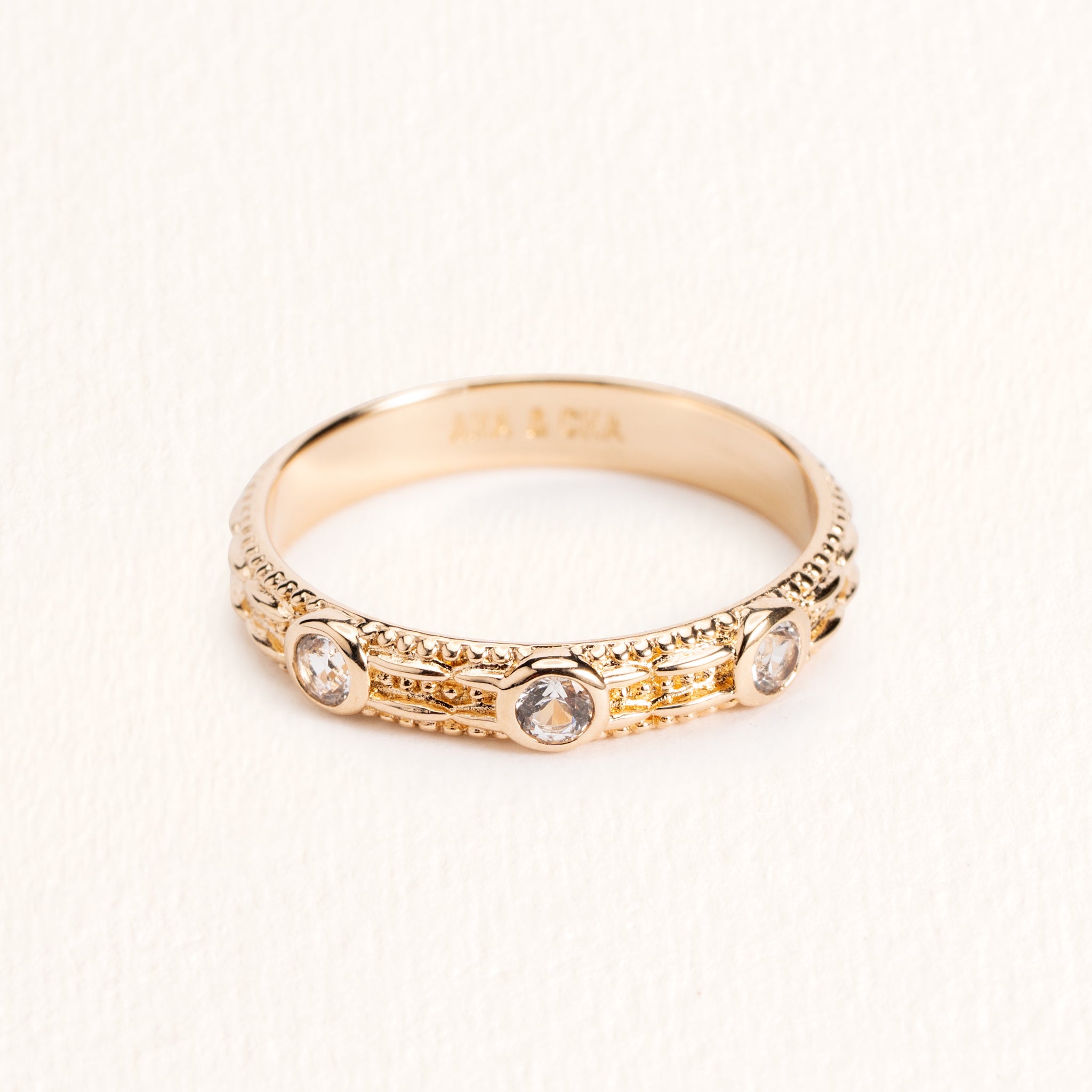 Bague Astra dorée en plaqué or 18 carats ornée de trois topazes blanches et d’un anneau fin texturé