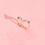 Bague Elsa dorée en plaqué or 18 carats ornée de plusieurs pierres naturelles bleues, violettes et blanches disposées en v autour de la moitié de l'anneau
