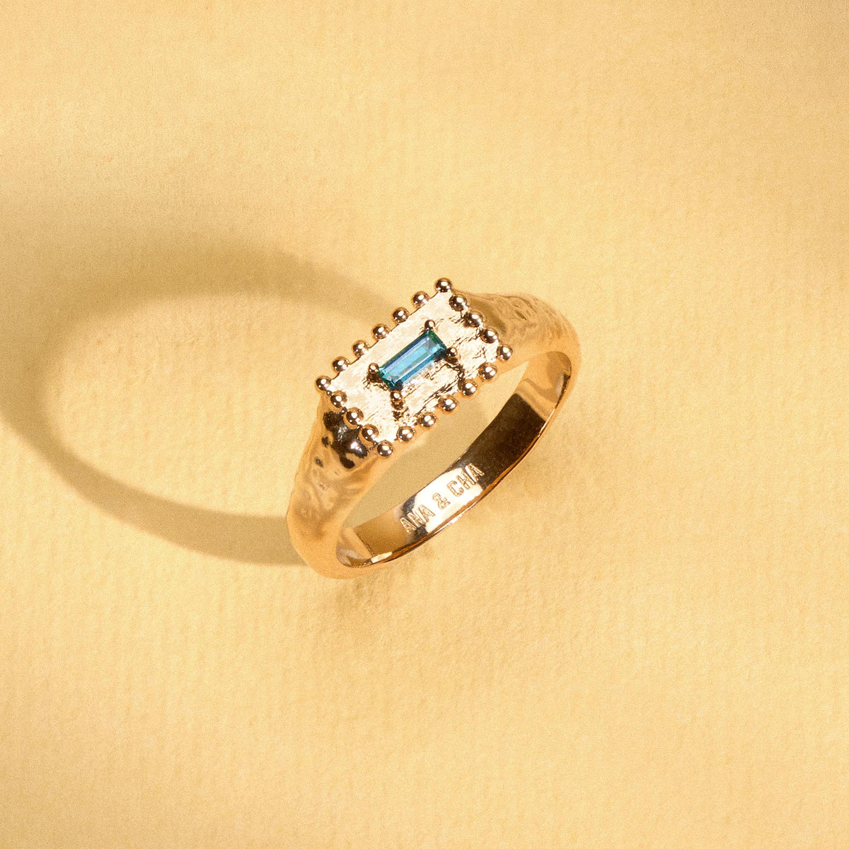 Bague Tania dorée en plaqué or 18 carats à la surface texturée, ornée d’une topaze London Blue rectangulaire au bleu profond