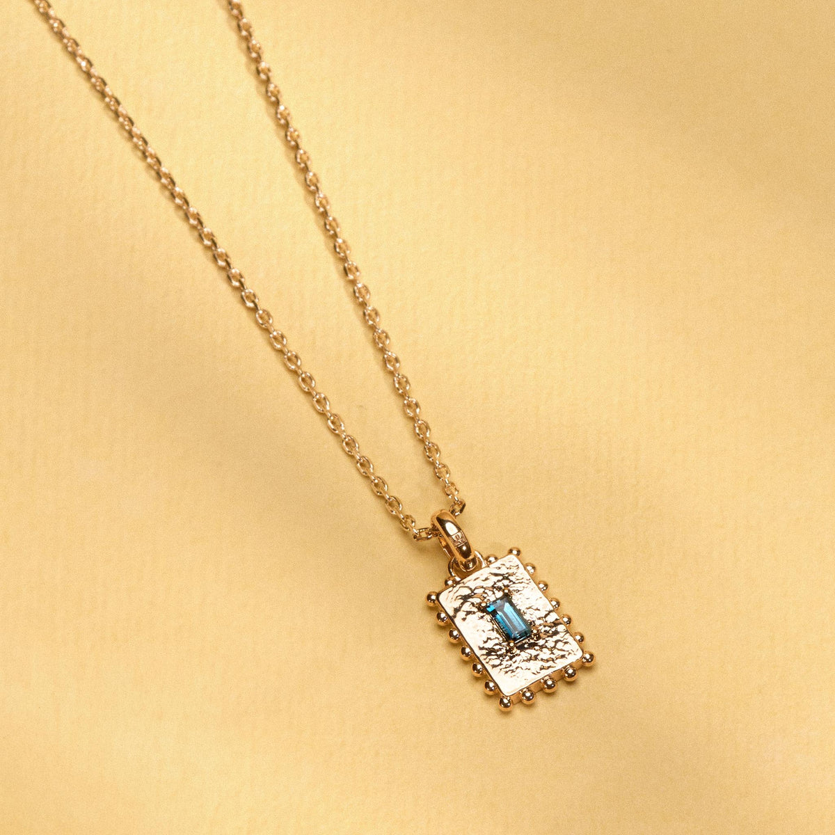 Collier Tania doré en plaqué or 18 carats avec pendentif rectangulaire texturé orné d’une topaze London Blue au bleu profond