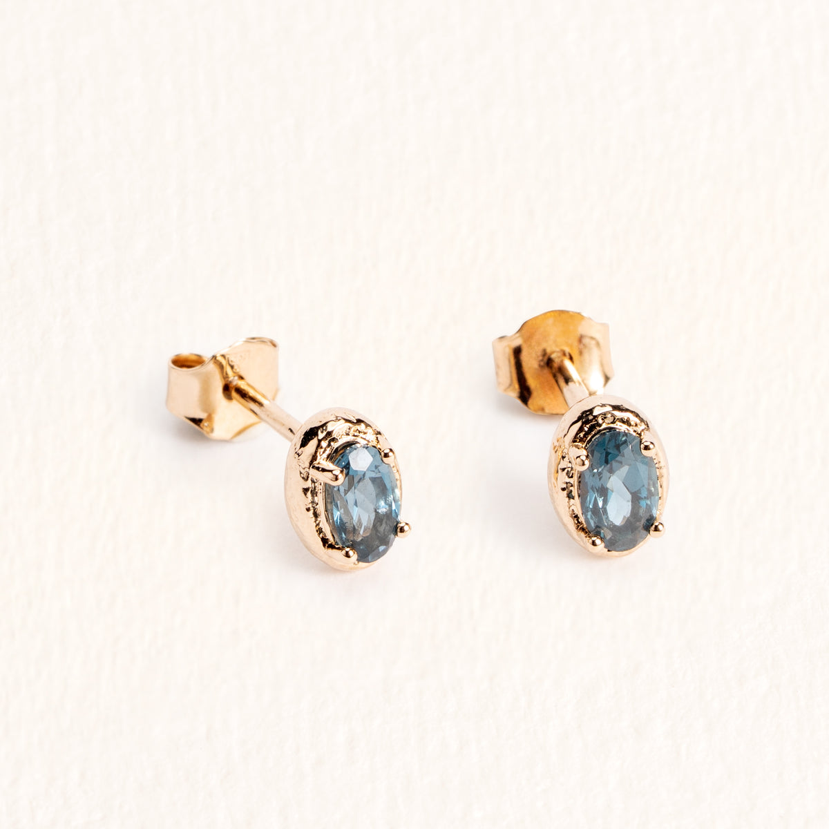 Puces d’oreilles Sienna dorées en plaqué or 18 carats ornées d’une topaze London Blue ovale au bleu profond