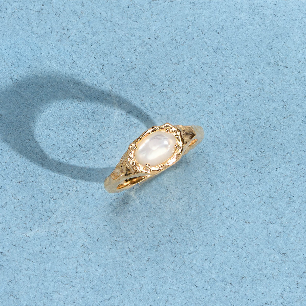 Bague Ilona dorée en plaqué or 18 carats ornée de nacre blanche irisée aux contours irréguliers et arrondis