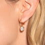 Créoles Ilona dorées en plaqué or 18 carats texturées avec pendentif en nacre blanche irisée aux contours irréguliers et arrondis