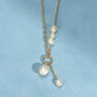 Collier Neva doré en plaqué or 18 carats avec chaîne fine ornée de plusieurs perles de culture blanches et d'un anneau avec deux perles pendantes