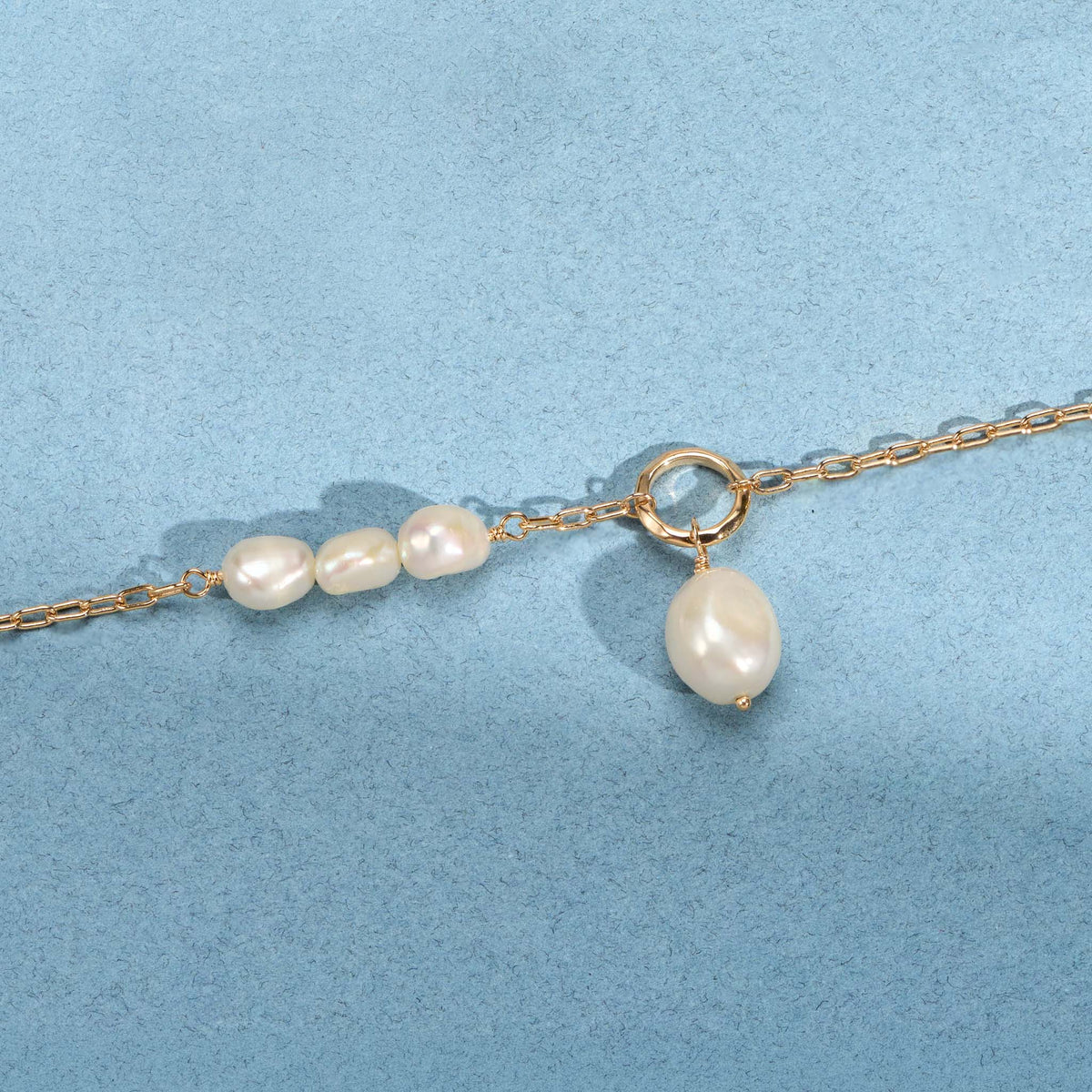 Bracelet Neva doré en plaqué or 18 carats avec chaîne fine ornée de plusieurs perles de culture blanches et d'un anneau avec une perle pendante