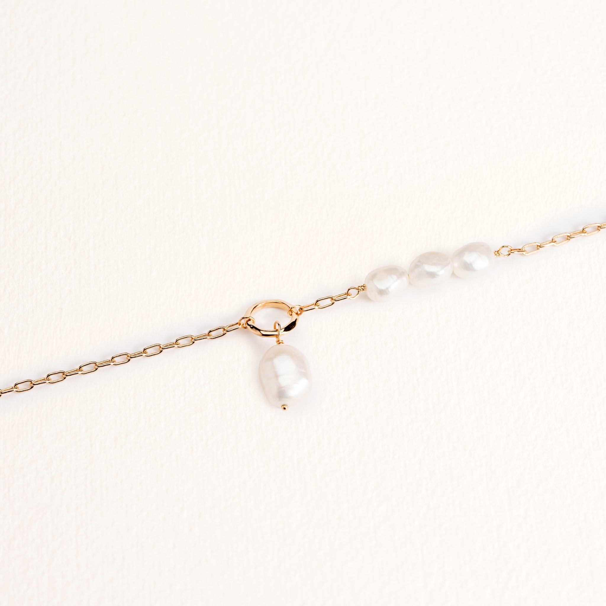 Bracelet Neva doré en plaqué or 18 carats avec chaîne fine ornée de plusieurs perles de culture blanches et d'un anneau avec une perle pendante