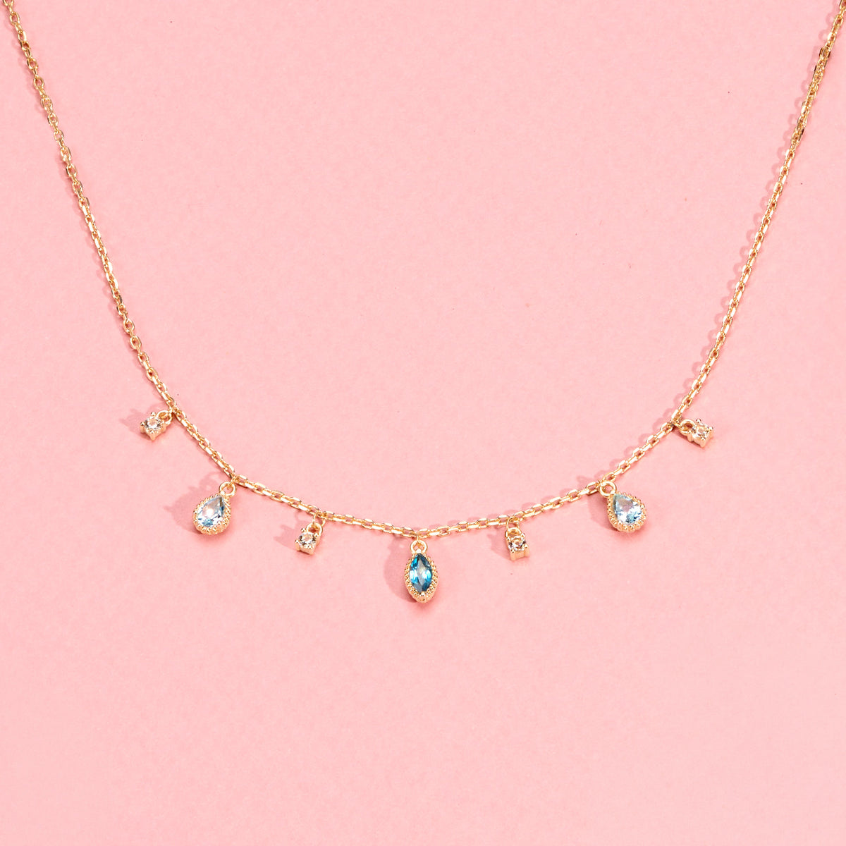 Collier Mira doré en plaqué or 18 carats avec chaîne fine ornée de topazes pendantes bleu profond, bleu clair et blanches