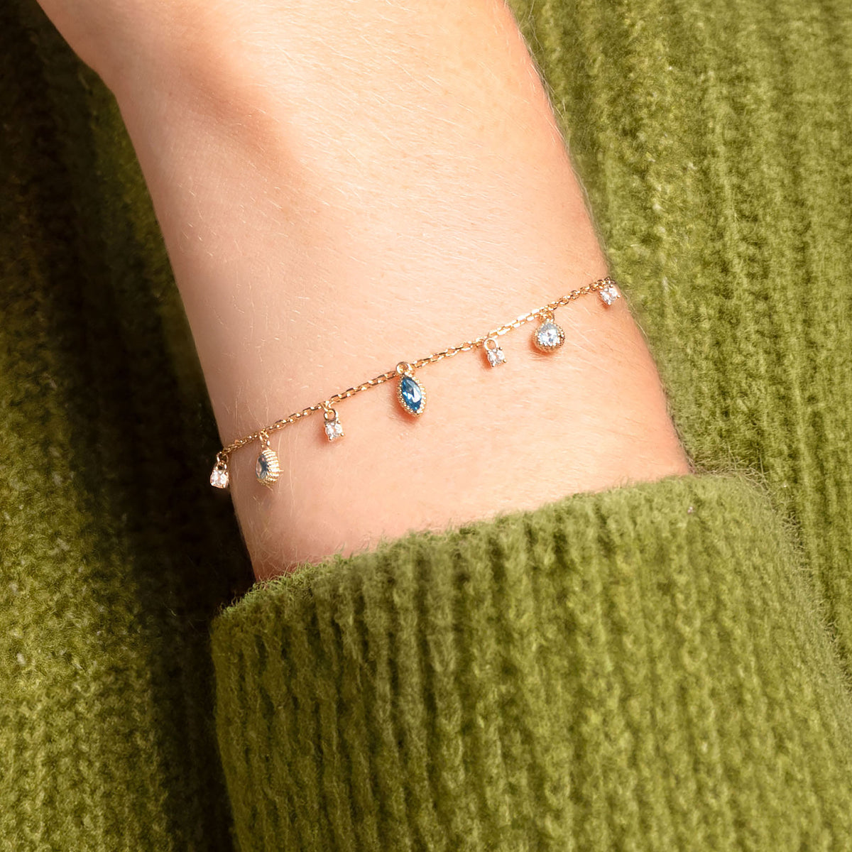 Bracelet Mira doré en plaqué or 18 carats avec chaîne fine ornée de topazes bleu profond, bleu clair et blanches