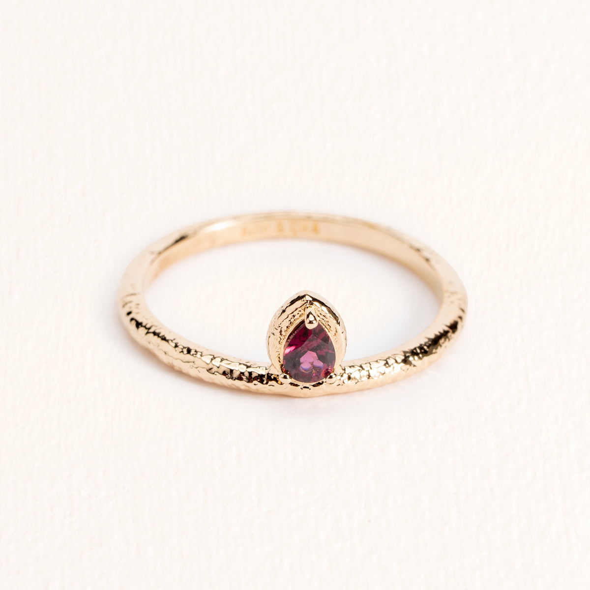 Bague Sienna dorée en plaqué or 18 carats avec anneau fin texturé, ornée d’une rhodolite ovale aux reflets framboise